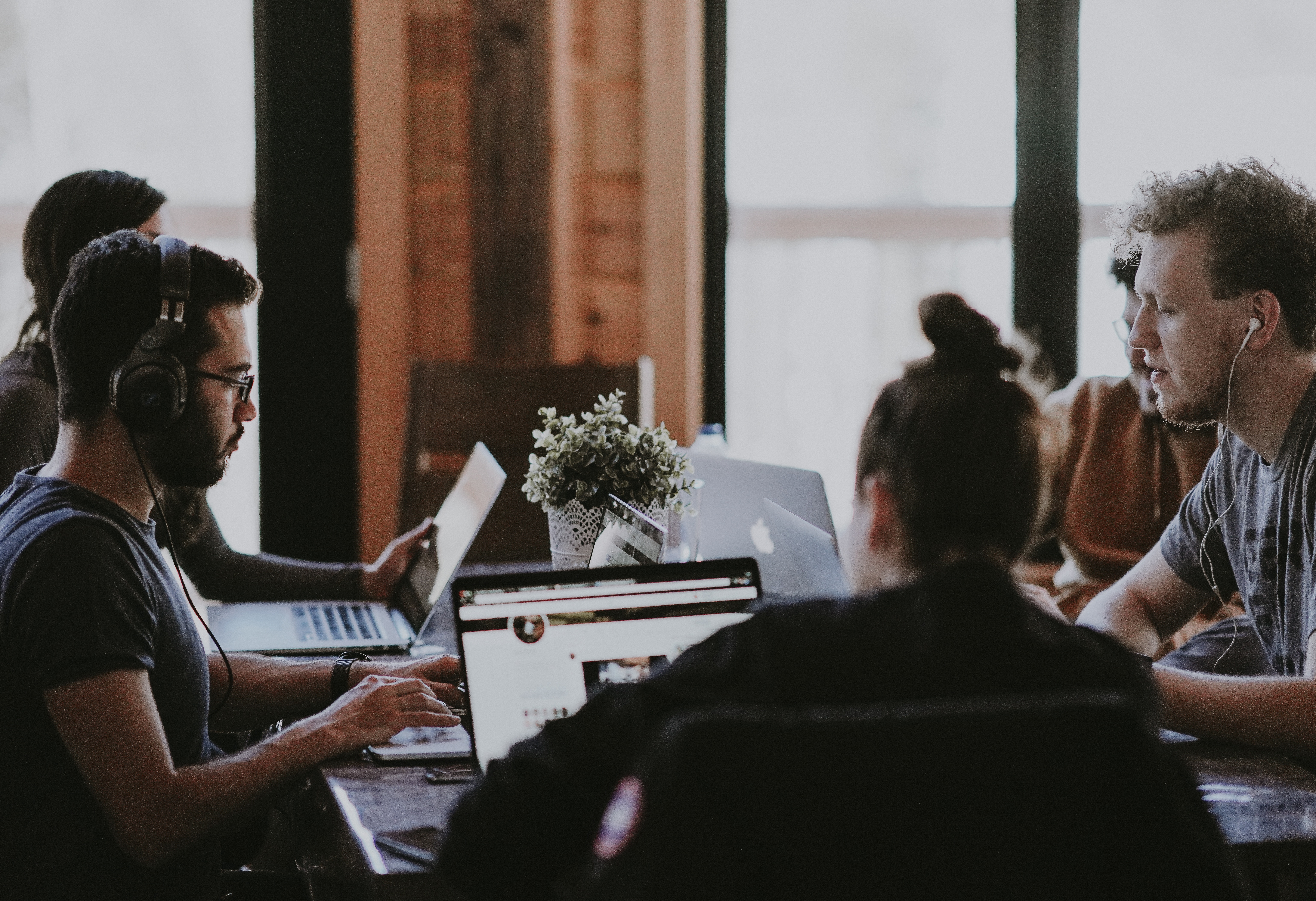 A group of people sit together in front of computers