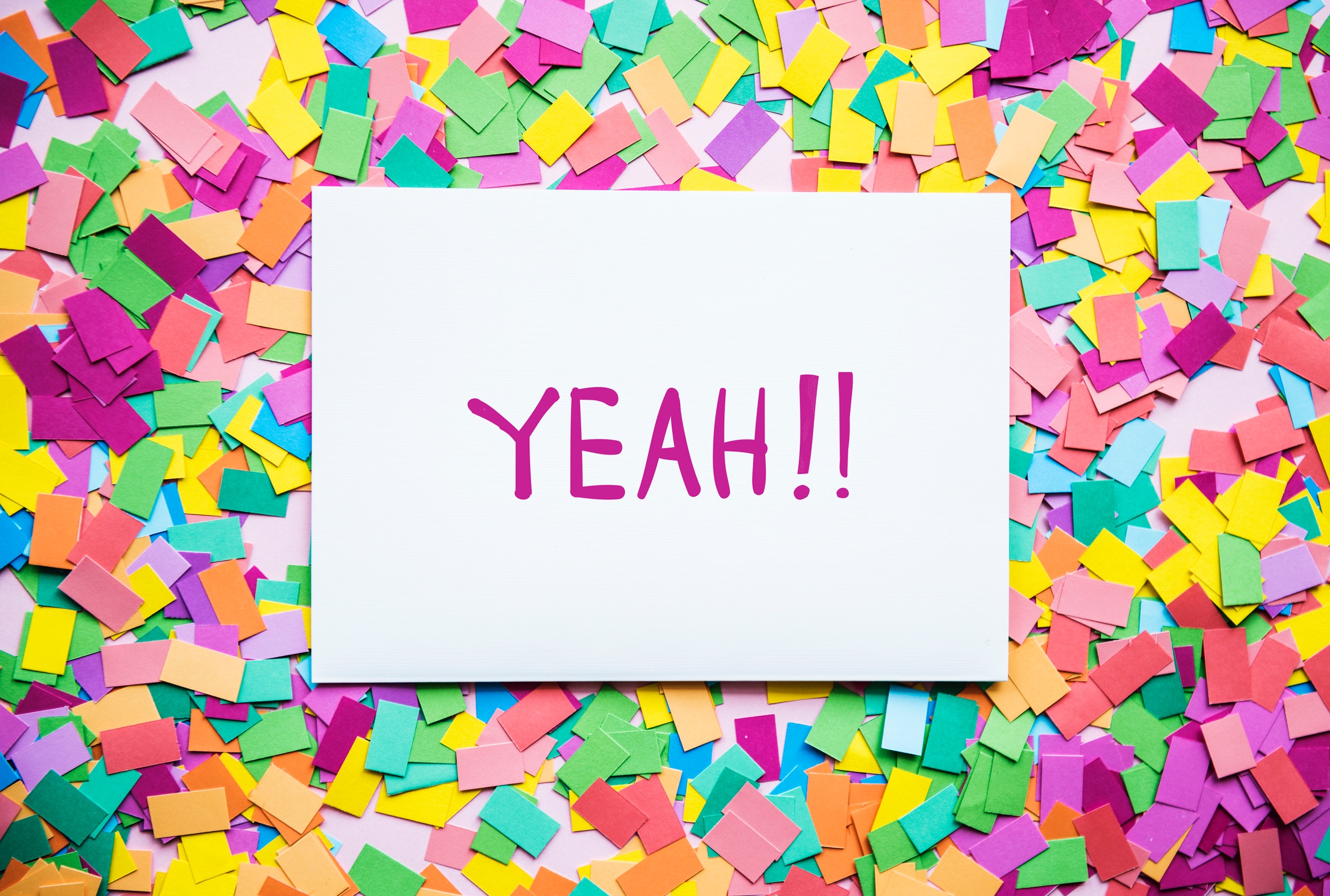 Card with the word "yeah" on top of confetti